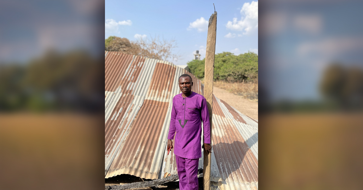 A man standing in front of a destroyed building.