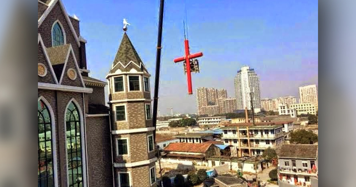 A cross is being removed from a building.