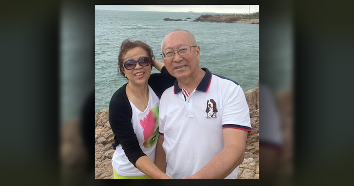 Elder Hao Ming is sitting with his wife at a shoreline.