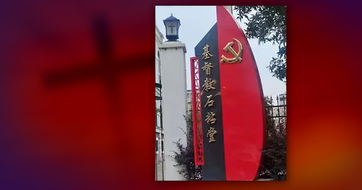 A sign in Chinese with a hammer and sickle mounted next to it. 