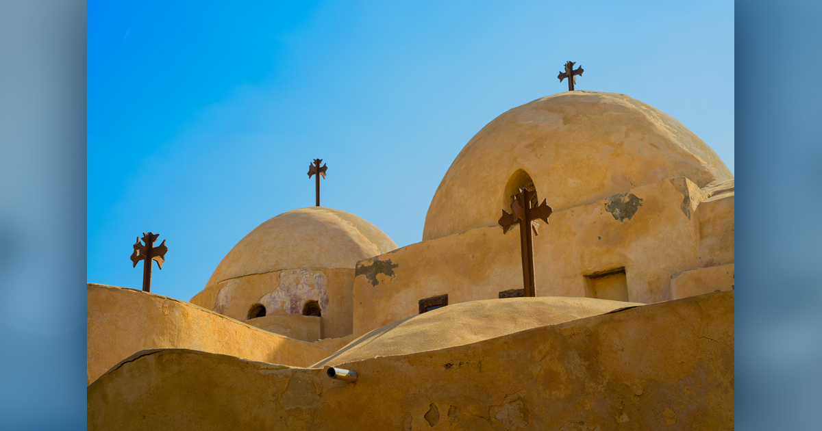 Multiple crosses sit atop of a church roof.