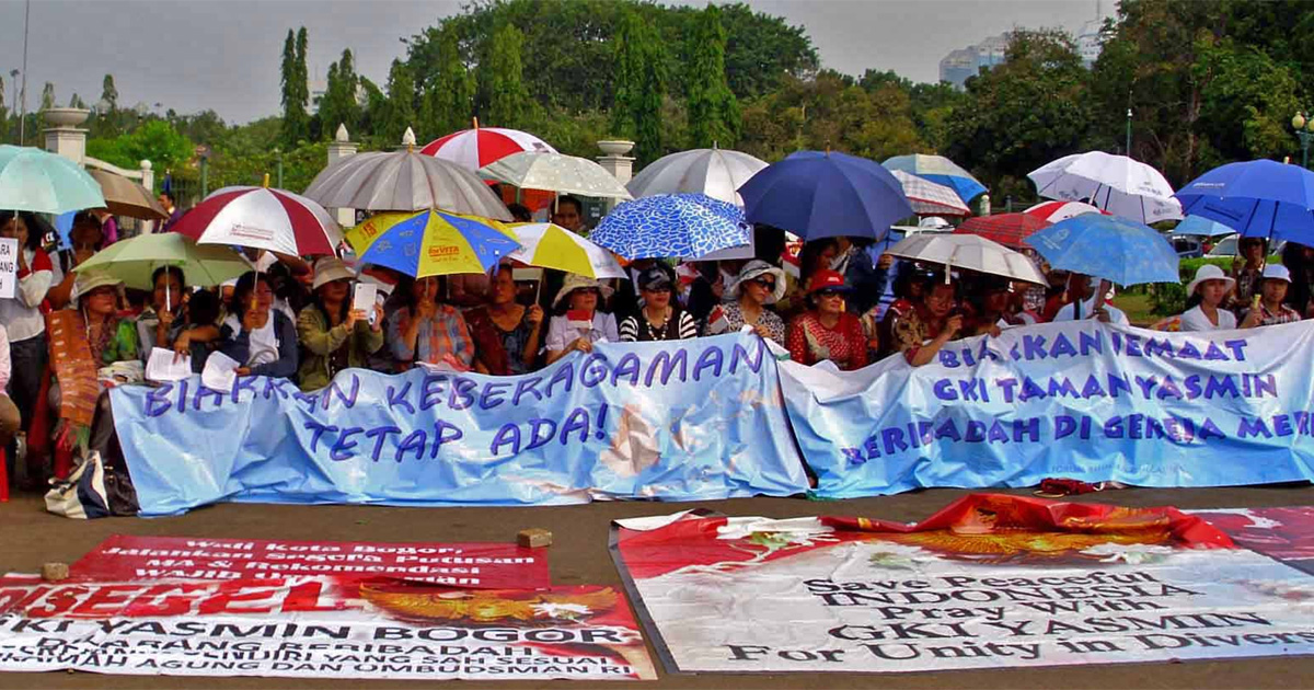 A group of people holding signs with the text, "Biarkan keberagaman tetap ada!" ("Let diversity remain!")