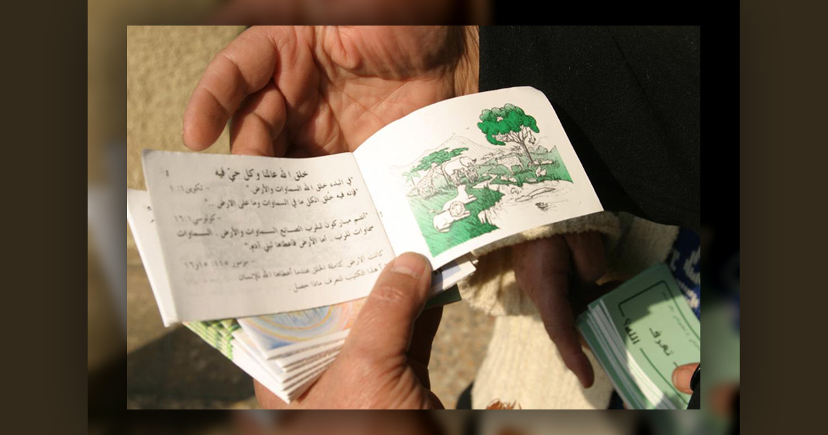 Man's hands holding a gospel tract