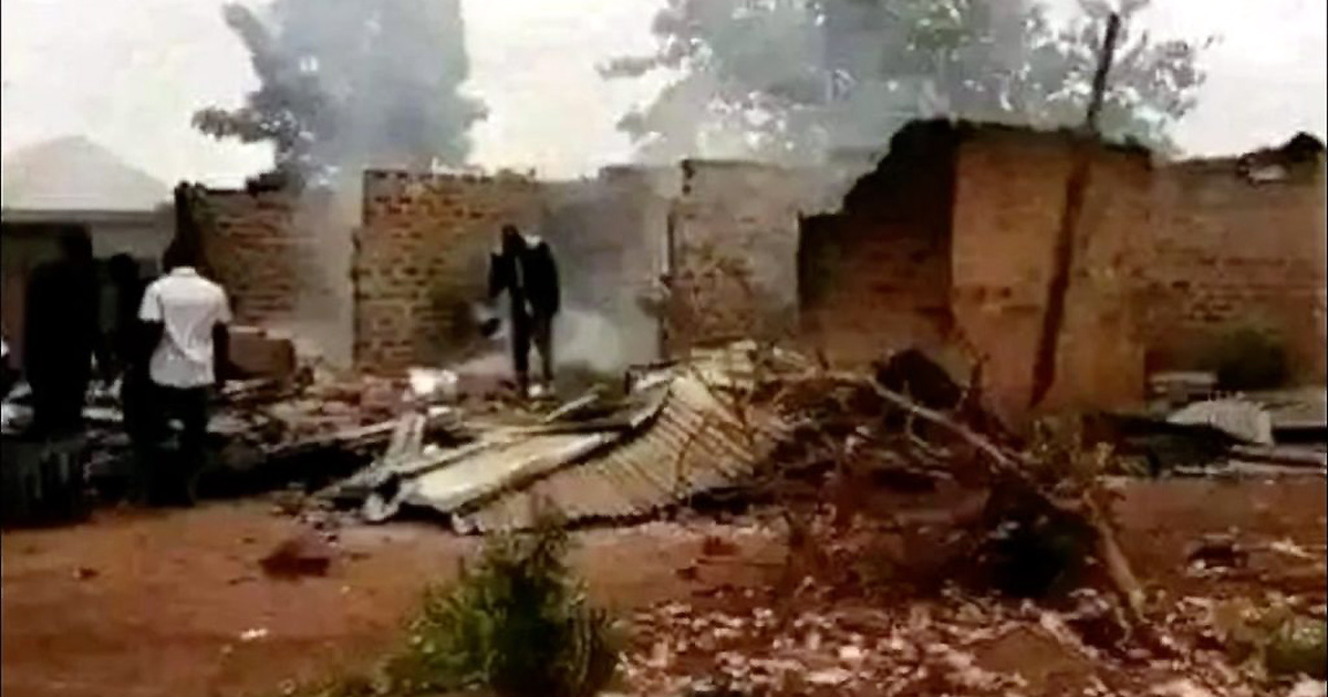 Two men walking amongst the rubble of buildings destroyed by fire.