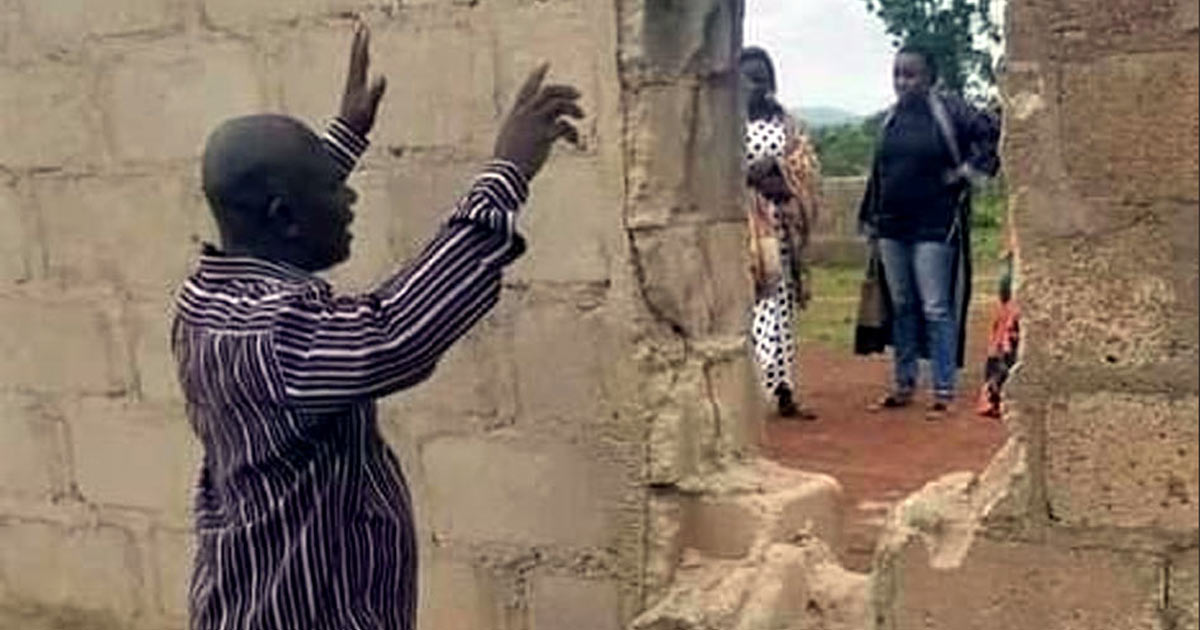 Father praying at breach in the wall - Photo: Morning Star News