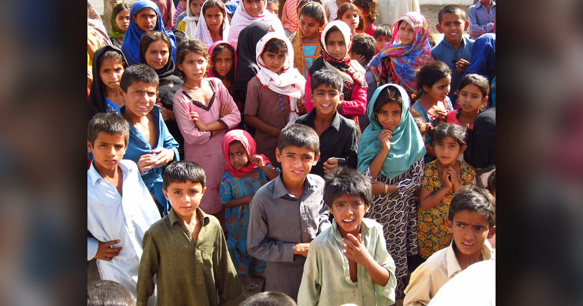 A group of children is looking up at the person taking the picture.