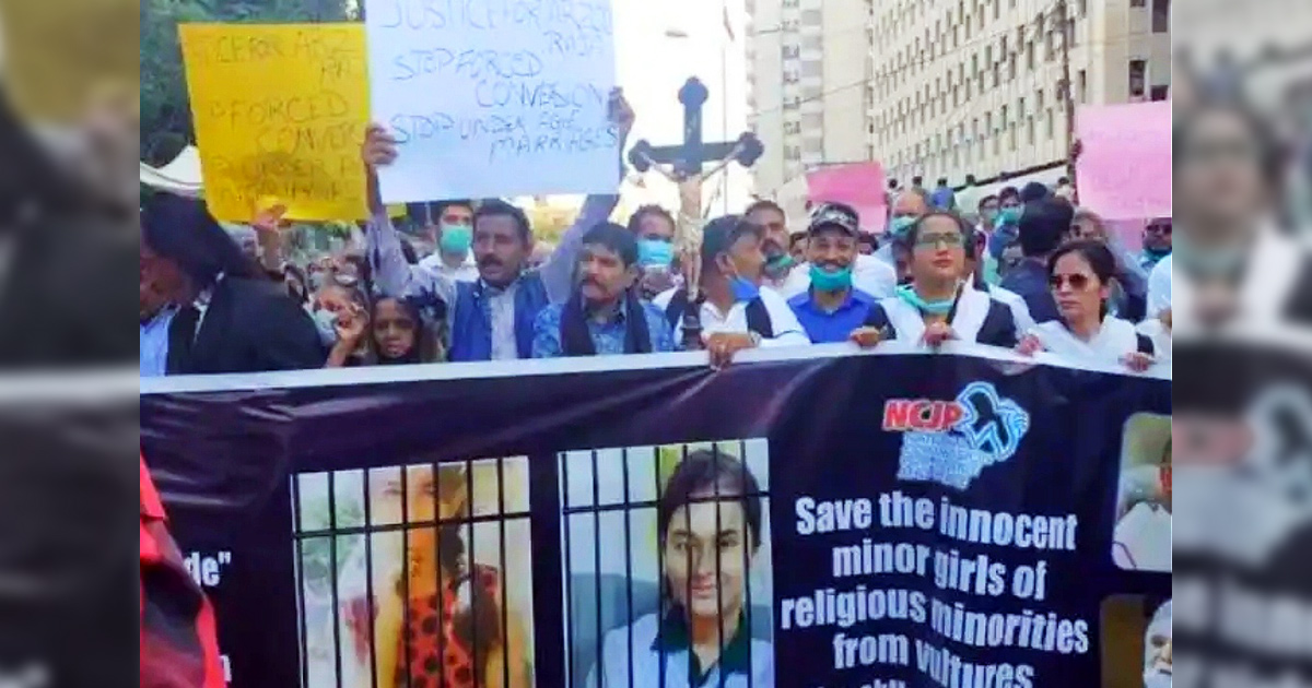 A large group of Christian protestors with signs, the most prominent one reading, ''Save the innocent minor girls of religious minorities from vultures... (remainder unreadable).''