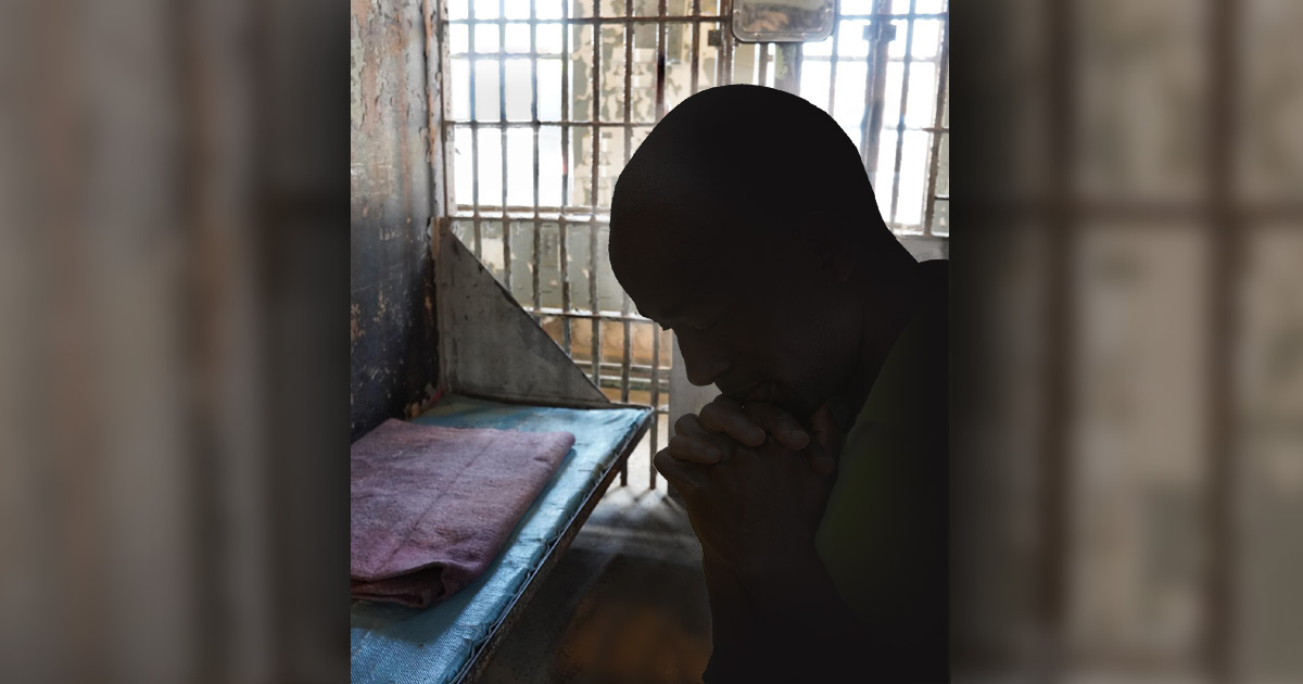 Silhouette of prisoner praying