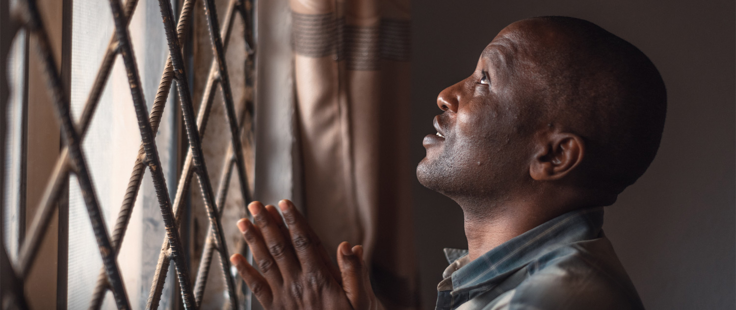 Man praying at a window
